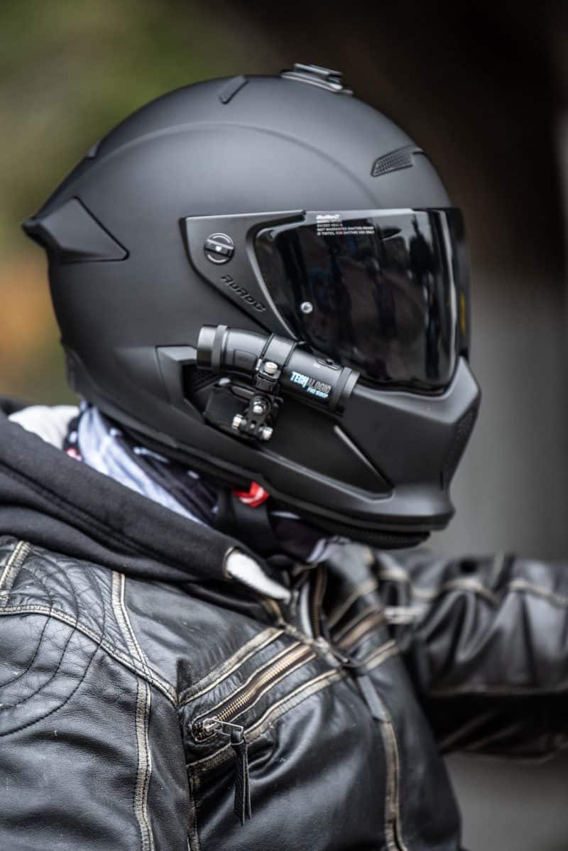 Man wearing black motorbike helmet with DC-1 Dual Lens Helmet Camera