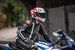 Man sitting on his blue motorcycle with a red and white helmet with the XV-1 2K QHD attached