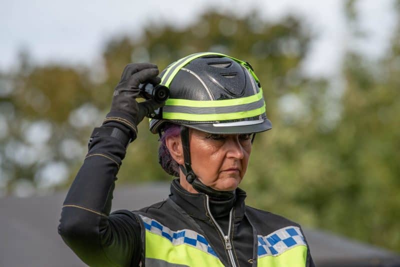Woman wearing green Equestrian helmet camera with XV-1 2K QHD Helmet Camera attached